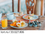 Tasty exotic fruits - ripe passion fruit, mango on breakfast at outdoor restaraunt. Стоковое фото, фотограф Дмитрий Травников / Фотобанк Лори