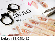 Папка с надписью "Дело" , наручники и российские денежные купюры. Стоковое фото, фотограф Николай Винокуров / Фотобанк Лори