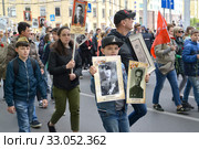 Мальчик несет в руках портреты родных - участников Великой Отечественной войны. Акция "Бессмертный полк". Калининград, 9 мая 2019 года. Редакционное фото, фотограф Ирина Борсученко / Фотобанк Лори