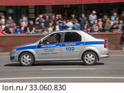 Российский автомобиль полиции Рено Логан едет после парада в честь Дня Победы по Новому Арбату, Москва, вид сбоку (2018 год). Редакционное фото, фотограф Малышев Андрей / Фотобанк Лори