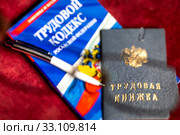 Трудовая книжка, Трудовой кодекс Российской Федерации и ручка лежат на столе (2020 год). Редакционное фото, фотограф Николай Винокуров / Фотобанк Лори