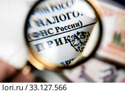 Выпущенный приказ Федеральной налоговой службой Российской Федерации под увеличительным стеклом. Стоковое фото, фотограф Николай Винокуров / Фотобанк Лори