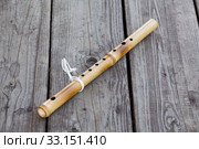 Seven-holed bamboo flute lying on square-edged flooring. Стоковое фото, фотограф Кекяляйнен Андрей / Фотобанк Лори