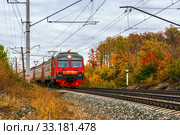 Russia, Samara, September 2019: Passenger train with wagons Ed4m moves by rail through the beautiful Autumn Forest. Редакционное фото, фотограф Акиньшин Владимир / Фотобанк Лори
