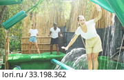 Group of excited people passing water obstacle course at adventure park. Стоковое видео, видеограф Яков Филимонов / Фотобанк Лори