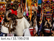 Ряженые Кукери из села Айдемир в Болгарии в традиционных костюмах идут по улице (2020 год). Редакционное фото, фотограф Николай Винокуров / Фотобанк Лори