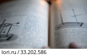 Ufa, Russia - FEB 15: man leafs through an old German physics textbook circa 1890 on February 14, 2015 in Ufa, Russia. Close up. Редакционное видео, видеограф Mikhail Erguine / Фотобанк Лори