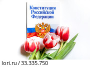 Брошюра "Конституция Российской Федерации" с букетом цветов на белом фоне. Стоковое фото, фотограф Николай Винокуров / Фотобанк Лори