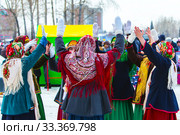 Девушки одетые в национальную старинную русскую одежду и яркие платки водят хоровод на празднике Масленицы. Город Бердск, Новосибирская область, Западная Сибирь, Россия (2020 год). Редакционное фото, фотограф Евгений Мухортов / Фотобанк Лори
