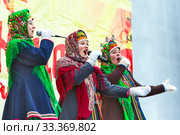 Девушки в национальных старинных русских костюмах выступают на сцене. Праздник Масленицы, Бердск, Новосибирская область, Западная Сибирь, Россия (2020 год). Редакционное фото, фотограф Евгений Мухортов / Фотобанк Лори