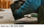 Concrete industry in the workshop - a man working with a chisel to clean up the form. Стоковое видео, видеограф Константин Шишкин / Фотобанк Лори