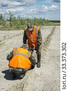Рекультивация участка добычи нефти. Посадка саженцев сосны. Reclamation of an oil production site. Planting pine seedlings. (2015 год). Редакционное фото, фотограф Евгений Романов / Фотобанк Лори