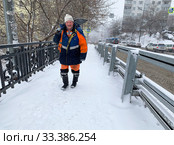 Дворник с лопатой на улице Владивостока в период циклона (2020 год). Редакционное фото, фотограф Овчинникова Ирина / Фотобанк Лори