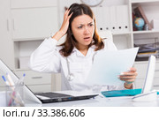 Upset practicioner girl is working with documents and laptop. Стоковое фото, фотограф Яков Филимонов / Фотобанк Лори