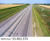 Wide highway with four lanes, aerial view at straight motorway in agricultural fields. Russia. Стоковое фото, фотограф Кекяляйнен Андрей / Фотобанк Лори