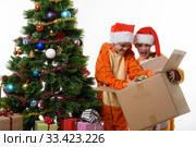 Девочка смешно держит коробку с новогодними игрушками, другая девочка копается в коробке. Стоковое фото, фотограф Иванов Алексей / Фотобанк Лори