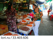 Молодая женщина с ребенком покупает продукты. Рынок Чо Дам (Cho Dam). Вьетнам, город Нячанг (2015 год). Редакционное фото, фотограф Щеголева Ольга / Фотобанк Лори