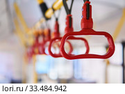 Grab handles in the passenger compartment of the bus on a blurred background. Стоковое фото, фотограф Евгений Харитонов / Фотобанк Лори
