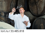Positive house sommelier tasting red wine. Стоковое фото, фотограф Яков Филимонов / Фотобанк Лори