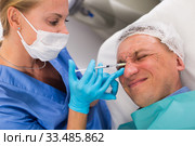 Female doctor is doing injection to patient in skin of face. Стоковое фото, фотограф Яков Филимонов / Фотобанк Лори
