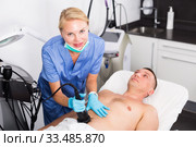 Female doctor is doing vacuum massage procedure for anti-fat to patient. Стоковое фото, фотограф Яков Филимонов / Фотобанк Лори