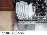 Dishwasher is loaded with utensils, clear dishes after washing, top view. Стоковое фото, фотограф Кекяляйнен Андрей / Фотобанк Лори