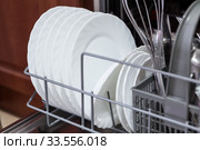 White clear plates and saucers are in dishwasher machine, close up view. Стоковое фото, фотограф Кекяляйнен Андрей / Фотобанк Лори