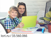 Девочка и мама делают уроки онлайн и посмотрели в кадр. Стоковое фото, фотограф Иванов Алексей / Фотобанк Лори