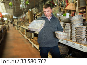 Puzzled man choosing wickerwork in shop. Стоковое фото, фотограф Яков Филимонов / Фотобанк Лори