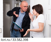 Collector is trying to get the arrears from woman at home door. Стоковое фото, фотограф Яков Филимонов / Фотобанк Лори
