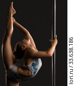 Pole dance. Flexible girl doing vertical split. Стоковое фото, фотограф Гурьянов Андрей / Фотобанк Лори