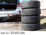 Four summer tyres are next to opened trunk of suv car, seasonal tire change. Стоковое фото, фотограф Кекяляйнен Андрей / Фотобанк Лори