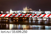 Coronavirus in Prague, Czech Republic. Vltava river, Charles Bridge and St. Vitus Cathedral. Quarantine sign on a blurred background. Concept of COVID pandemic and travel in Europe. (2019 год). Стоковое фото, фотограф Владимир Журавлев / Фотобанк Лори