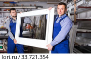 Production workers in coverall with different finished PVC profiles and windows at factory. Стоковое фото, фотограф Яков Филимонов / Фотобанк Лори