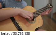 Teenage hand plucks the strings of a yellow acoustic guitar, close up view (2020 год). Редакционное видео, видеограф Кекяляйнен Андрей / Фотобанк Лори
