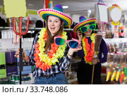 Comically dressed young woman joking in festive accessories store. Стоковое фото, фотограф Яков Филимонов / Фотобанк Лори