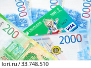 Кредитная карта Visa с Забивакой - талисманом Чемпионата мира по футболу FIFA лежит на новых денежных купюрах (2018 год). Редакционное фото, фотограф Елена Коромыслова / Фотобанк Лори