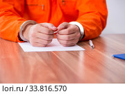 Young man writing letter in provisional detention. Стоковое фото, фотограф Elnur / Фотобанк Лори