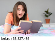 Девушка в легком шоке от прочитанного в книге. Стоковое фото, фотограф Иванов Алексей / Фотобанк Лори