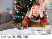 Senior woman engaged in home accounting in the new year holiday. Стоковое фото, фотограф Яков Филимонов / Фотобанк Лори