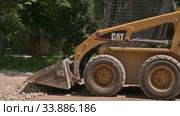 Skid steer loader moving sand soil at construction area outdoors. Редакционное видео, видеограф Сергей Старуш / Фотобанк Лори