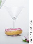 A glass of martini and a pink and white striped donut close-up. photo for the screensaver. Стоковое фото, фотограф Evgeny Miller / Фотобанк Лори