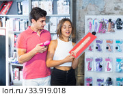 woman and man bayers choosing long rubber phallus in the sex shop. Стоковое фото, фотограф Яков Филимонов / Фотобанк Лори