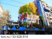 Hundertwasser house in Vienna, Austria. The Hundertwasserhaus apartment block has colorful facade, undulating floors, a roof covered with earth and grass, and large trees growing from inside (2019 год). Редакционное фото, фотограф Nataliia Zhekova / Фотобанк Лори