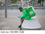 Курьер сервиса доставки еды Delivery Club на улице в Москве (2020 год). Редакционное фото, фотограф Victoria Demidova / Фотобанк Лори