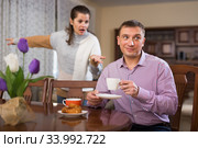 Irritated young spouses quarrelling in home interio. Стоковое фото, фотограф Яков Филимонов / Фотобанк Лори