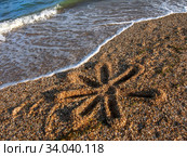 Солнышко, нарисованное на крупном песке. Волны морского прибоя на заднем плане. Природная текстура. Черноморское побережье Крыма, Россия. Стоковое фото, фотограф Маргарита Лир / Фотобанк Лори