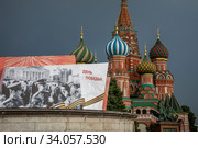 Праздничный баннер на Красной площади на фоне Храма Василия Блаженного в центре города Москвы, приуроченное к военному параду в честь 75-летия Победы в Великой Отечественной войне 24 июня 2020. Редакционное фото, фотограф Николай Винокуров / Фотобанк Лори
