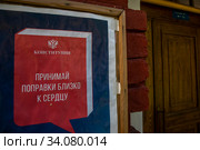 Информационный плакат о проведении общероссийского голосования по поправкам в Конституцию Российской Федерации 1 июля 2020 висит у подъезда жилого дома в центре города Москвы, Россия. Редакционное фото, фотограф Николай Винокуров / Фотобанк Лори