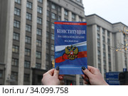 Девушка держит в руках брошюру конституции Российской Федерации на против здания Государственной Думы (2020 год). Редакционное фото, фотограф Кузнецов Максим / Фотобанк Лори